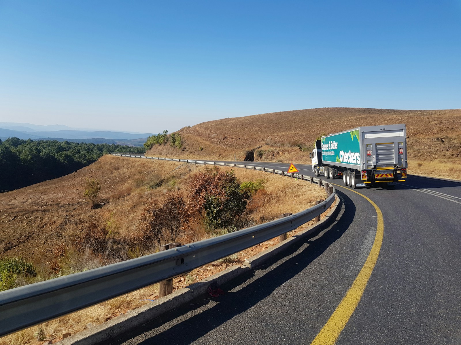 white and blue commercial truck on road during daytime